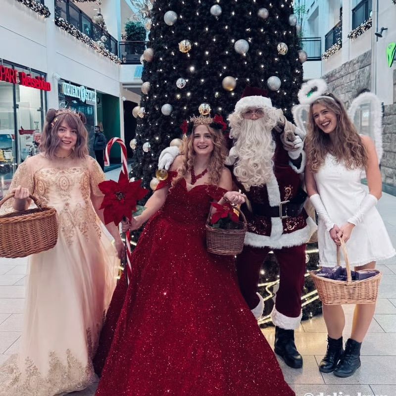 Weihnachtsmann mit Weihnachtsengel und zwei Prinzessinnen im Einkaufszentrum